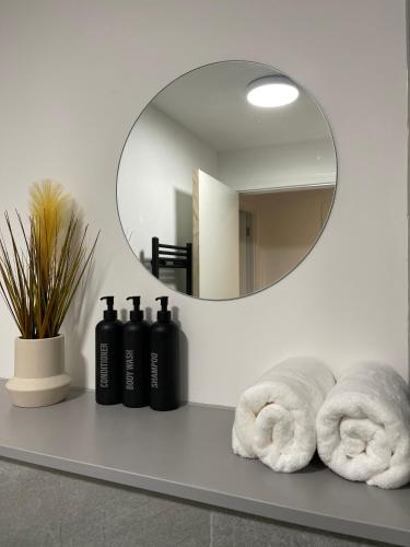 a bathroom counter with a mirror and towels on it at 3 Bedroom Apartment in Preston - Stunning City View in Preston