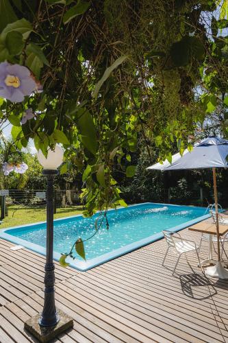 a swimming pool with a light pole and an umbrella at Pousada Villa Agrifoglio in Praia do Rosa