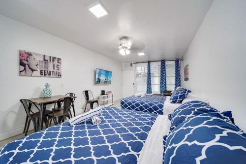 a bedroom with two beds and a table at Deco Beachside Apt, w/2 Queen Beds, Washer/Dryer in Miami Beach