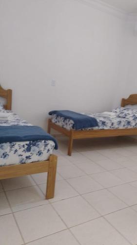 two beds sitting next to each other in a room at POUSADA DAS NAÇÕES lll in Indaiatuba