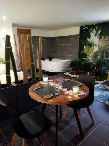 une salle à manger avec une table et une baignoire dans l'établissement Studio romantique à Baixas avec Jacuzzi - 35m², à Baixas
