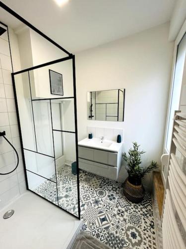 une salle de bain avec un lavabo et un miroir dans l'établissement Le vintage, à Charleville-Mézières