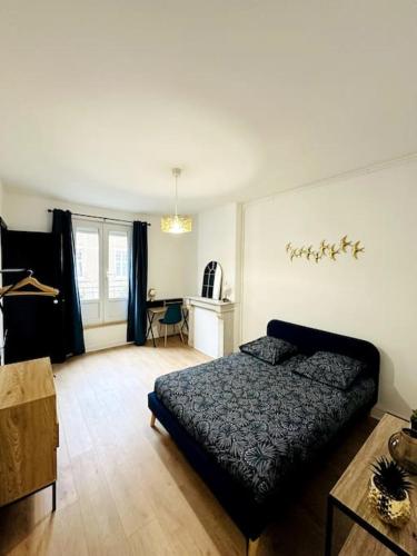 une chambre avec un lit et un bureau dans l'établissement Le vintage, à Charleville-Mézières