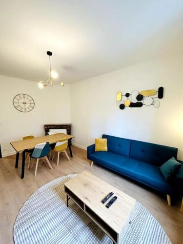 un salon avec un canapé bleu et une table dans l'établissement Le vintage, à Charleville-Mézières