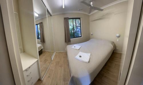 a small bedroom with a bed and a mirror at 1770 Holiday Village in Seventeen Seventy