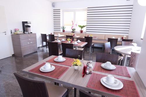 a dining room with tables and chairs and a table and chairsktop at Aristo Hotel in Filderstadt