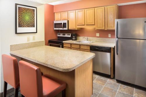 a kitchen with a stainless steel refrigerator and cabinets at Residence Inn Orlando Altamonte Springs / Maitland in Orlando
