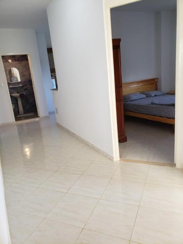 a room with a bed and a tiled floor at Résidence Maya in El Haouaria