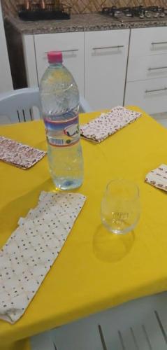 a bottle of water sitting on a table with a glass at Résidence Maya in El Haouaria