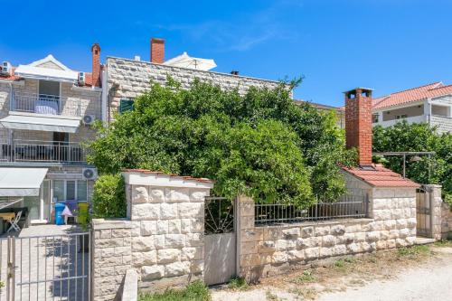 a stone wall with a tree in front of a building at Double Room Supetar 5658d in Supetar