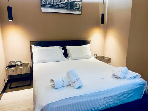 a bedroom with a large white bed with towels on it at Hotel Olive in Vlorë