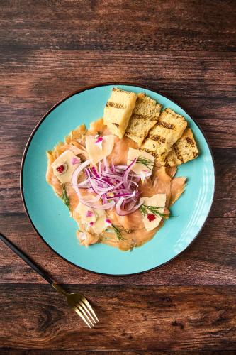 a blue plate with food on a wooden table at Ficus Sunset Suites in Monteverde Costa Rica