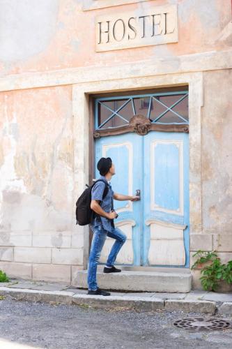 un homme debout devant une porte bleue dans l'établissement Hostel do Vinni 01, à São José dos Campos