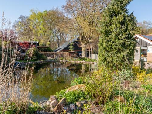 a house with a pond in front of a house at Edelhert in Hulshorst