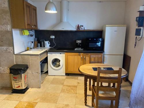 La cuisine est équipée d'une table, d'un évier et d'un réfrigérateur. dans l'établissement SOLEIL ET PLAGE A Sète, à Sète