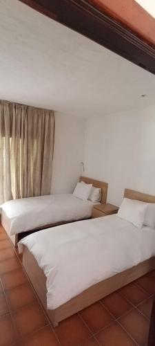 two beds sitting next to each other in a room at Kabila - accès Direct à La Plage in Sania Torres