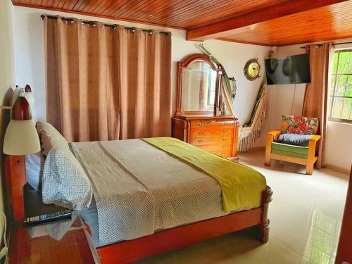 ein Schlafzimmer mit einem Bett, einer Kommode und einem Stuhl in der Unterkunft Alojamiento Morning Star Inn in Archibolds
