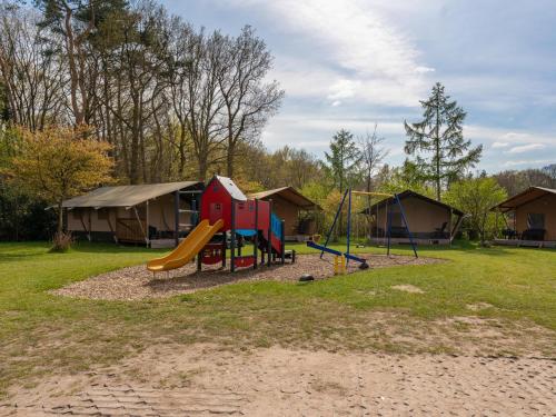 a park with a playground with a slide and tents at Edelhert in Hulshorst