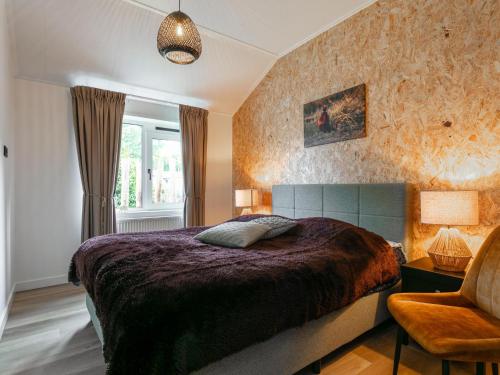 a bedroom with a bed and a chair and a window at De Fazant in Hulshorst