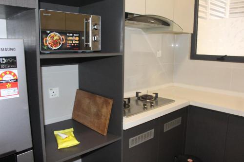 a small kitchen with a sink and a microwave at Country Garden Danga Bay in Johor Bahru