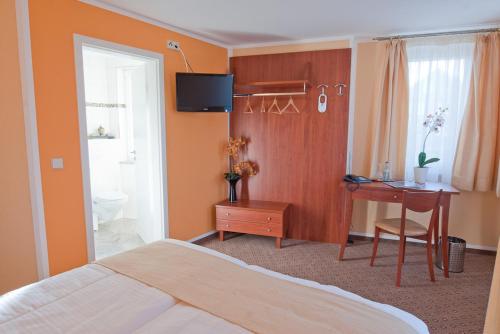 a hotel room with a bed and a desk and a desk at Aristo Hotel in Filderstadt