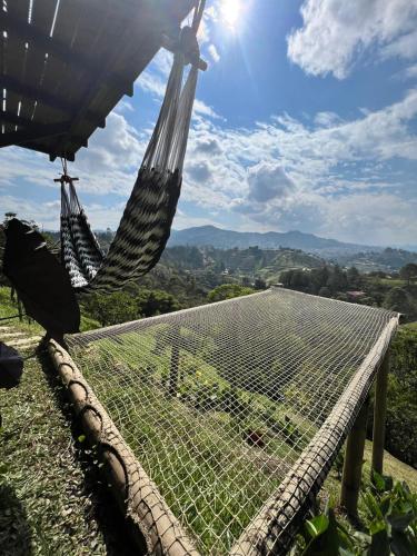 a hammock on top of a hill with a view at Eco Lodge Glamping in Guatapé