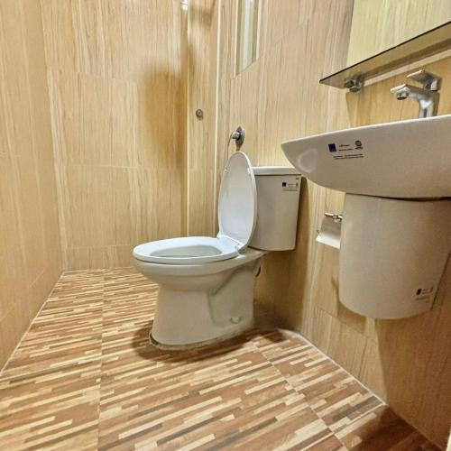 a bathroom with a toilet and a sink at Fatchoi Hotel in General Santos