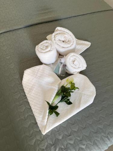 a table with white towels and flowers on it at Casa vacanze green house in Terrasini
