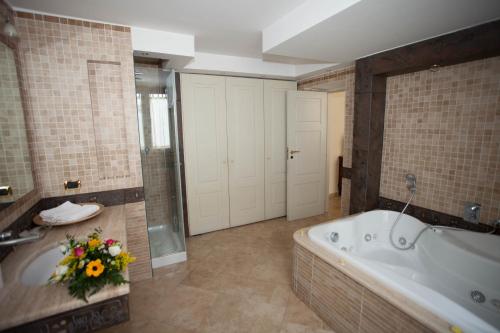 a large bathroom with a tub and flowers in it at B&B Nel Regno di Napoli in Naples