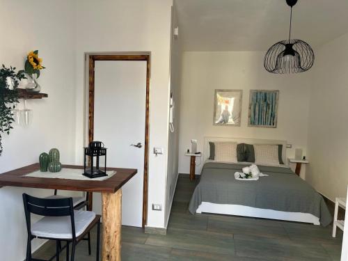 a bedroom with a bed and a table and a desk at Casa vacanze green house in Terrasini
