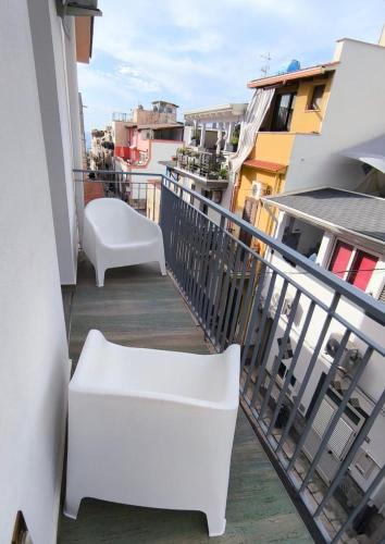 a balcony with two white chairs and a view at Casa vacanze green house in Terrasini