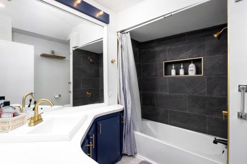 Un baño con bañera, lavabo y ducha. en 2 Bedroom Ft Moore Retreat, en Columbus