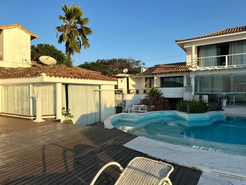 a house with a swimming pool in front of a house at Villa Romana Búzios in Búzios