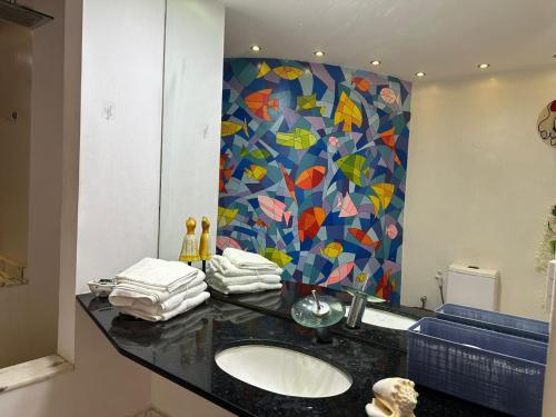 ein Badezimmer mit Waschbecken und bunter Wand in der Unterkunft Villa Romana Búzios in Búzios