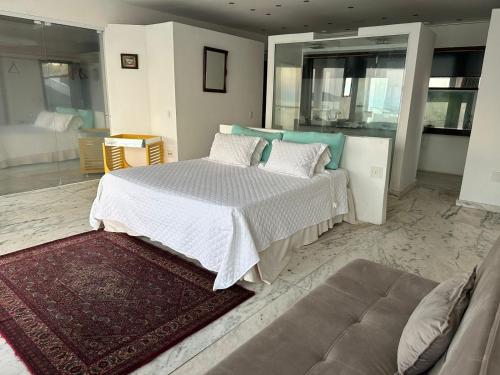 ein Schlafzimmer mit einem großen Bett und einer Couch in der Unterkunft Villa Romana Búzios in Búzios