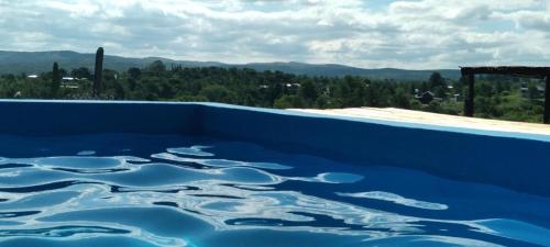 - une piscine bleue avec vue sur les montagnes dans l'établissement Cabaña Maria y Oscar, à Villa Giardino
