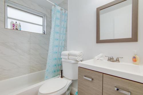 a bathroom with a toilet and a sink and a mirror at Private Ocean Dr Apt w/2 Queen Beds, Steps 2 Beach in Miami Beach
