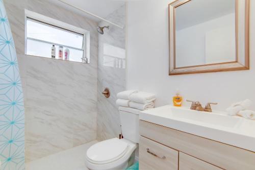 a bathroom with a toilet and a sink and a mirror at Steps 2 Beach, Prime Ocean Dr Condo w/2 Queen Beds in Miami Beach