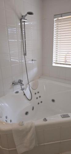 a white bathroom with a tub and a shower at Falls Mountain Retreat Blue Mountains in Wentworth Falls