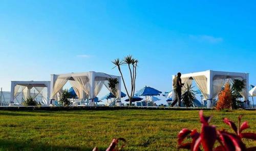 a group of white tents in a grass field at Chalet 3 room marina 5 in El Alamein
