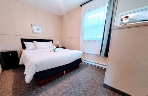 a bedroom with a large bed and a window at Lido Motel in Radium Hot Springs