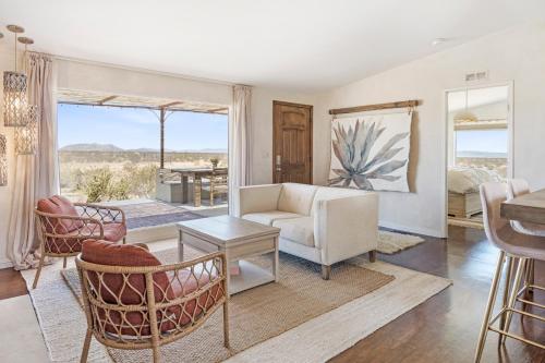 Una sala de estar con un sofá y sillas y una mesa. en Desert Moon - Serene Desert Views & Design home, en Joshua Tree