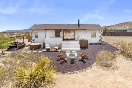 a home in the desert with chairs and a house at Desert Moon - Serene Desert Views & Design home in Joshua Tree