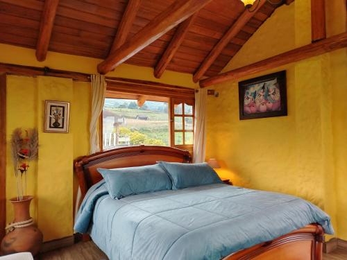 a bedroom with a bed with blue sheets and a window at Ruta de los volcanes in Machachi