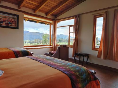 a hotel room with two beds and a large window at Ruta de los volcanes in Machachi