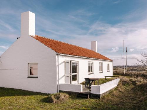 a small white house with a table in front of it at Villa Zuidwest 6, Garden, Dunes & Free parking in Zandvoort