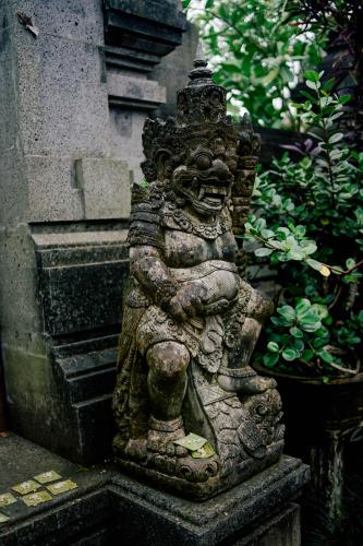a statue of a statue of a god in a garden at Homestay D'BANDEM in Penginyahan