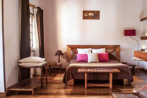 een slaapkamer met een bed met roze en witte kussens bij Couleur Café in Antsirabe
