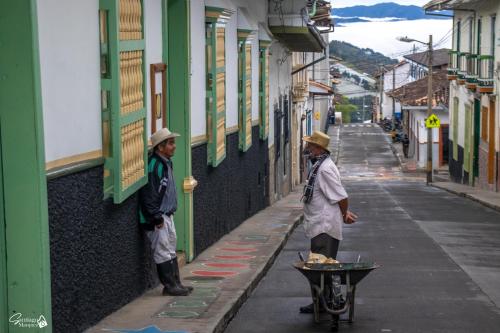 two men standing on the side of a street at Hotel El Tesoro Sonson in Sonsón