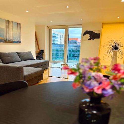 a living room with a vase of flowers on a table at Canary Wharf - Luxury Apartments in London
